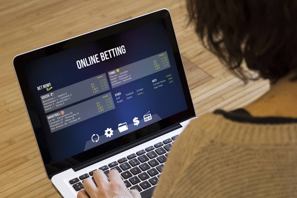 Persona usando una laptop para apuestas online, discutiendo qué hardware se necesita para jugar a juegos casino de manera óptima.