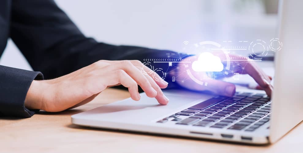 Manos trabajando en laptop con iconos de nube y tecnología, ilustrando IT staff augmentation para apps rápidas en la nube.