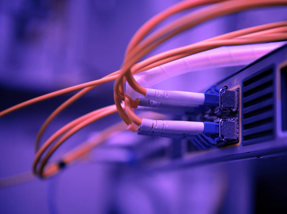 Cables de fibra óptica conectados a un switch de red. Alta velocidad y ancho de banda.