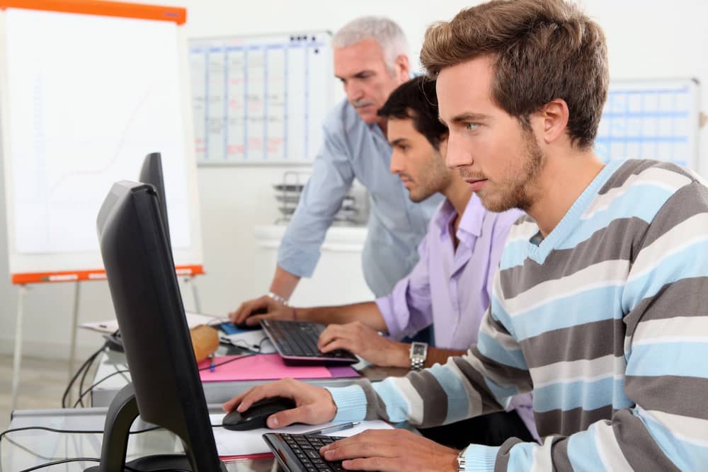 Estudiantes trabajando en computadoras en una clase de informática. ¿Es la informática para ti?
