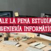 Escritorio con ordenadores mostrando código, ideal para estudiar ingeniería informática. Descubre si vale la pena estudiar ingeniería informática.