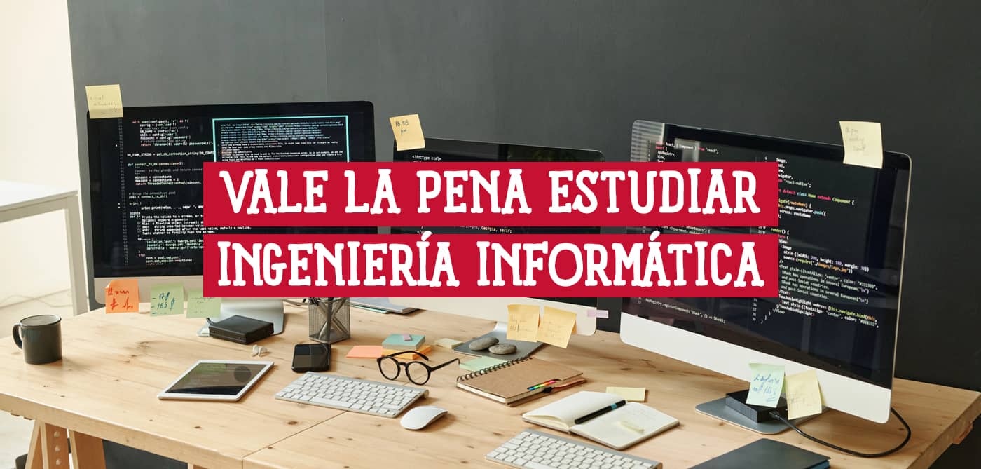 Escritorio con ordenadores mostrando código, ideal para estudiar ingeniería informática. Descubre si vale la pena estudiar ingeniería informática.